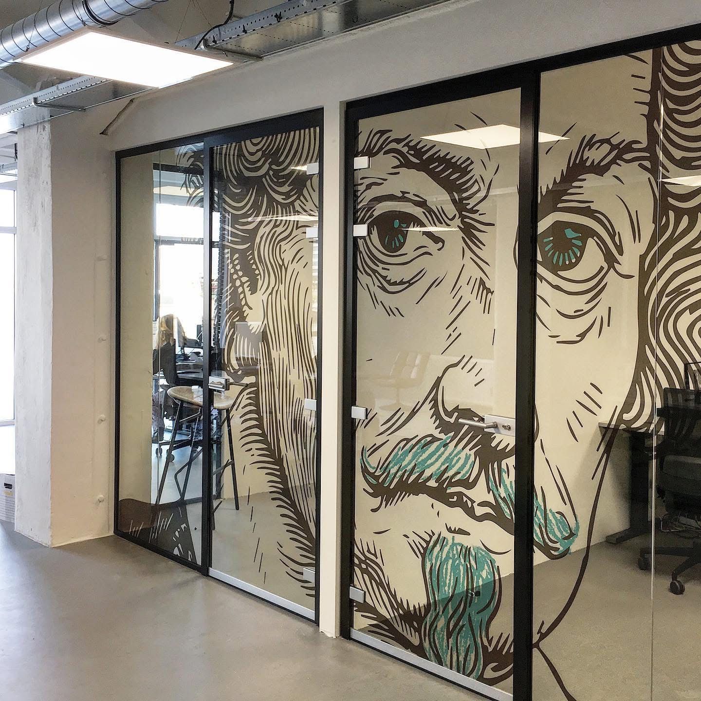 Glazen kantoordeuren met een groot, portret van Albert Einstein, uitgevoerd in zwarte, witte en turquoise inktlijnen.