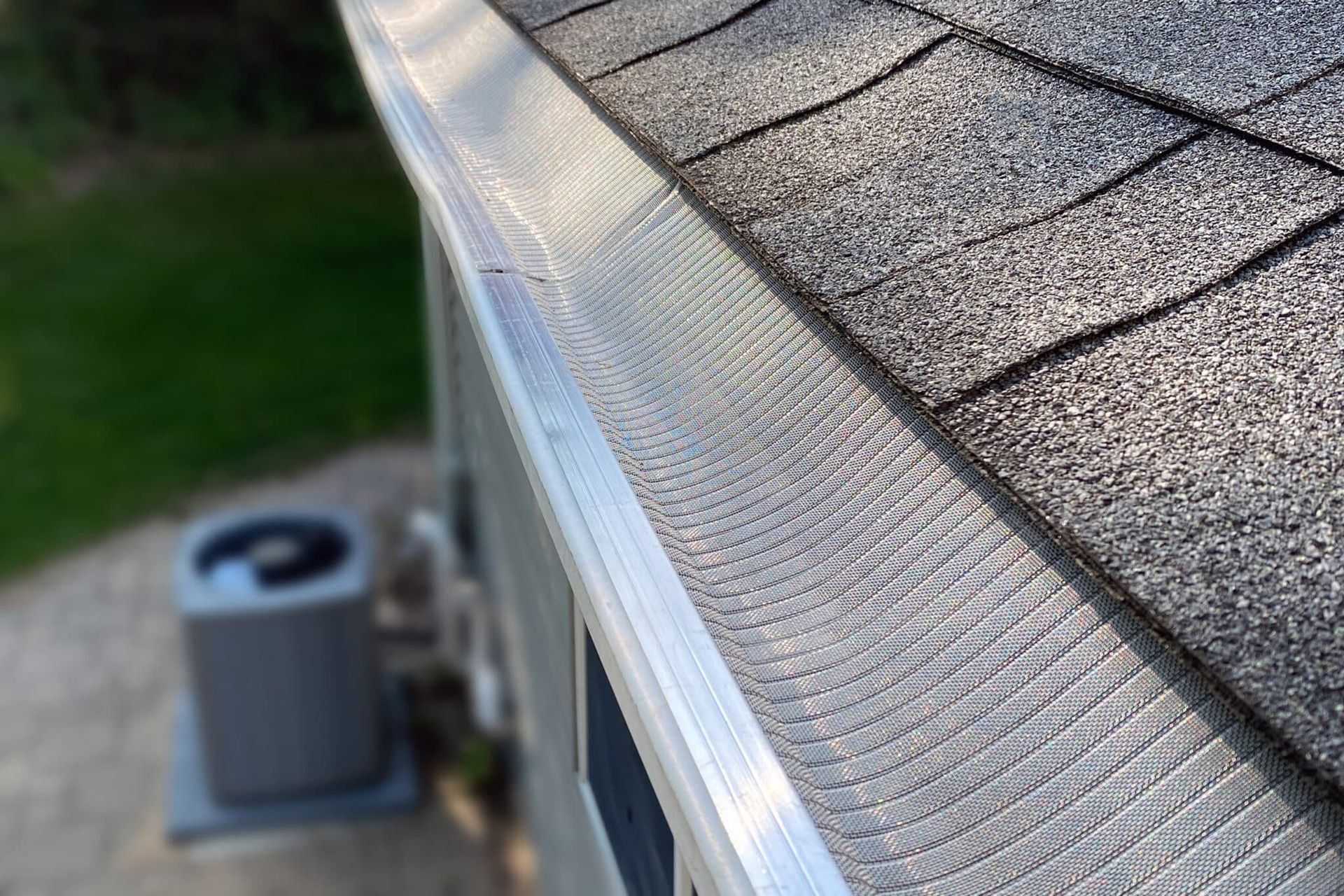A close-up view of a roof gutter system installed along the edge of a house.
