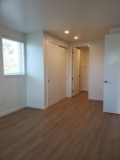 An empty room with hardwood floors and white walls