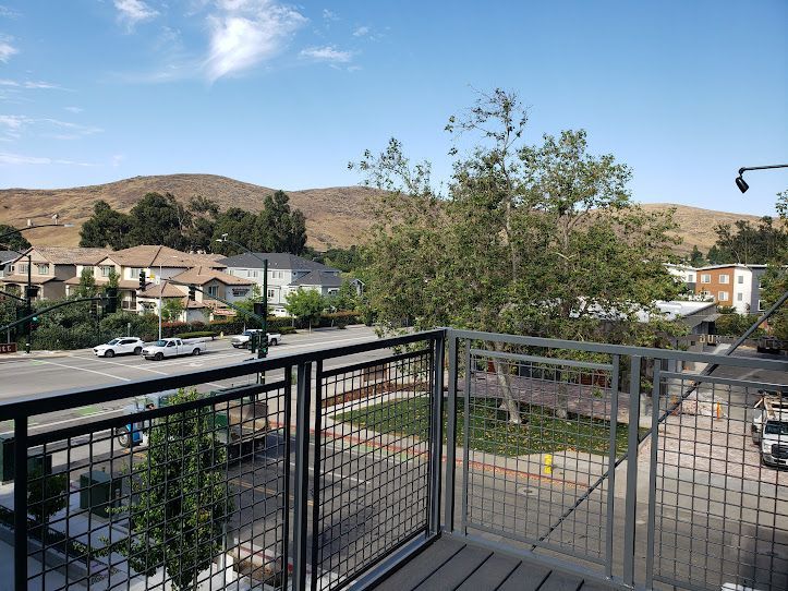 A balcony with a view of a city and mountains.