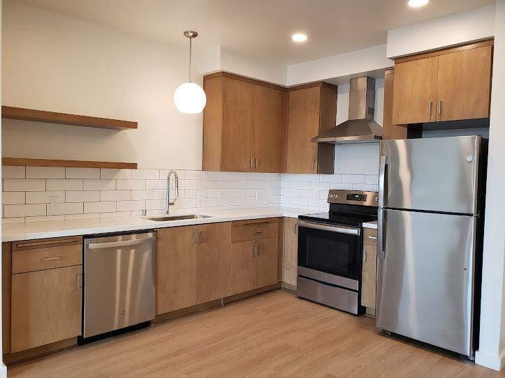 A kitchen with stainless steel appliances and wooden cabinets