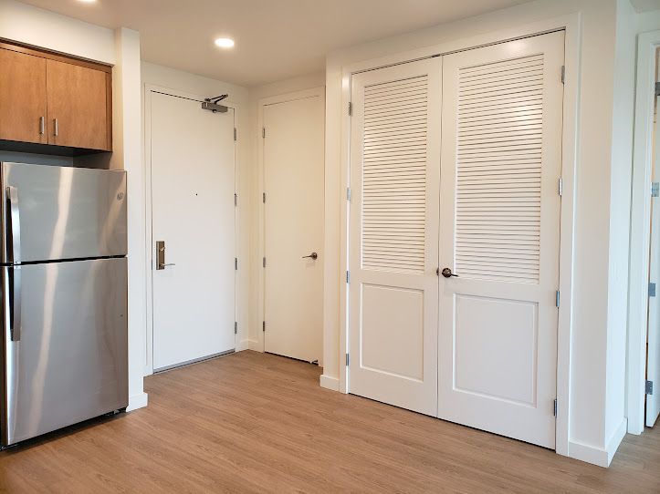 A kitchen with a stainless steel refrigerator and wooden cabinets