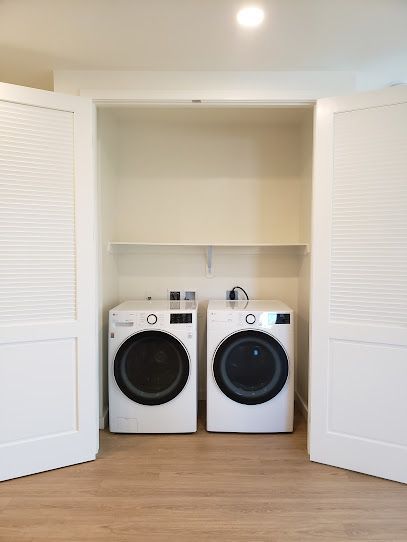 A laundry room with two washers and dryers in it