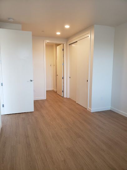 An empty room with hardwood floors and white walls.