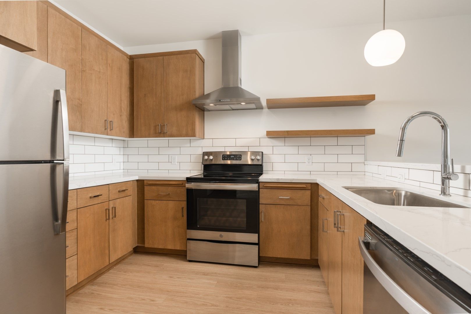 A kitchen with stainless steel appliances and wooden cabinets