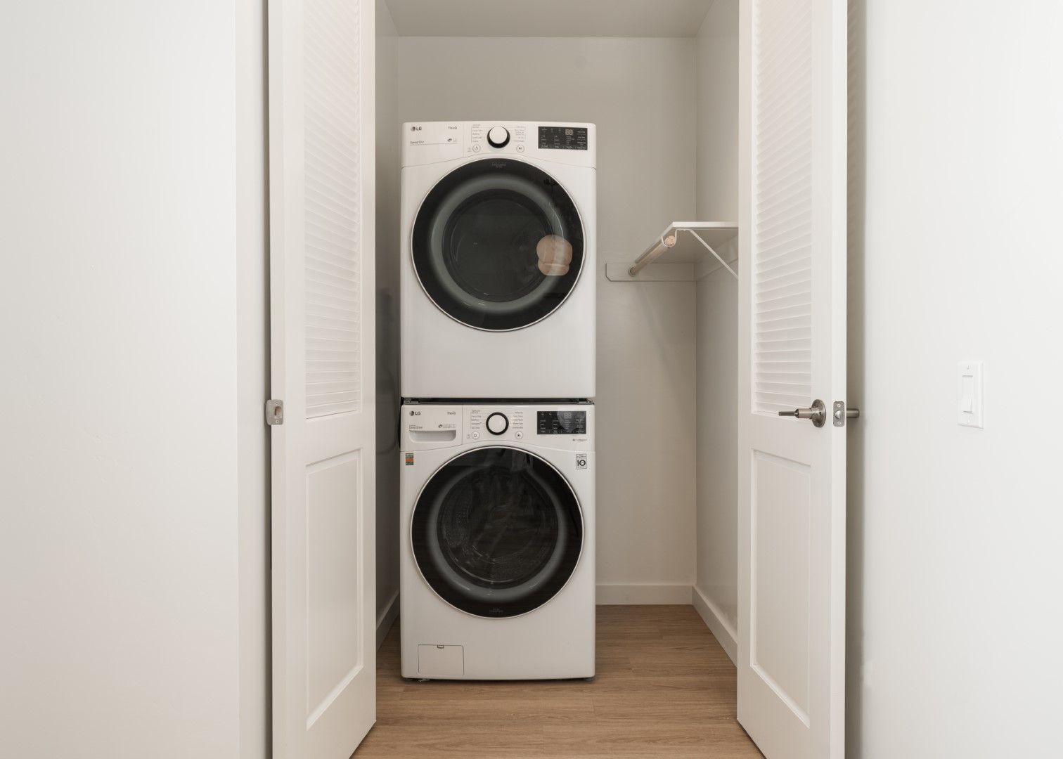 A washer and dryer are stacked on top of each other in a laundry room.