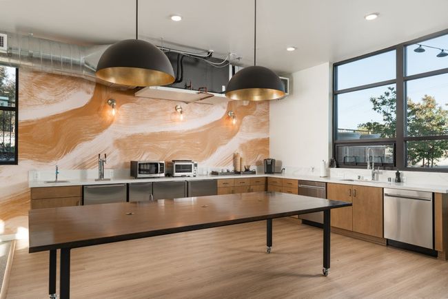 There is a large table in the middle of the kitchen.