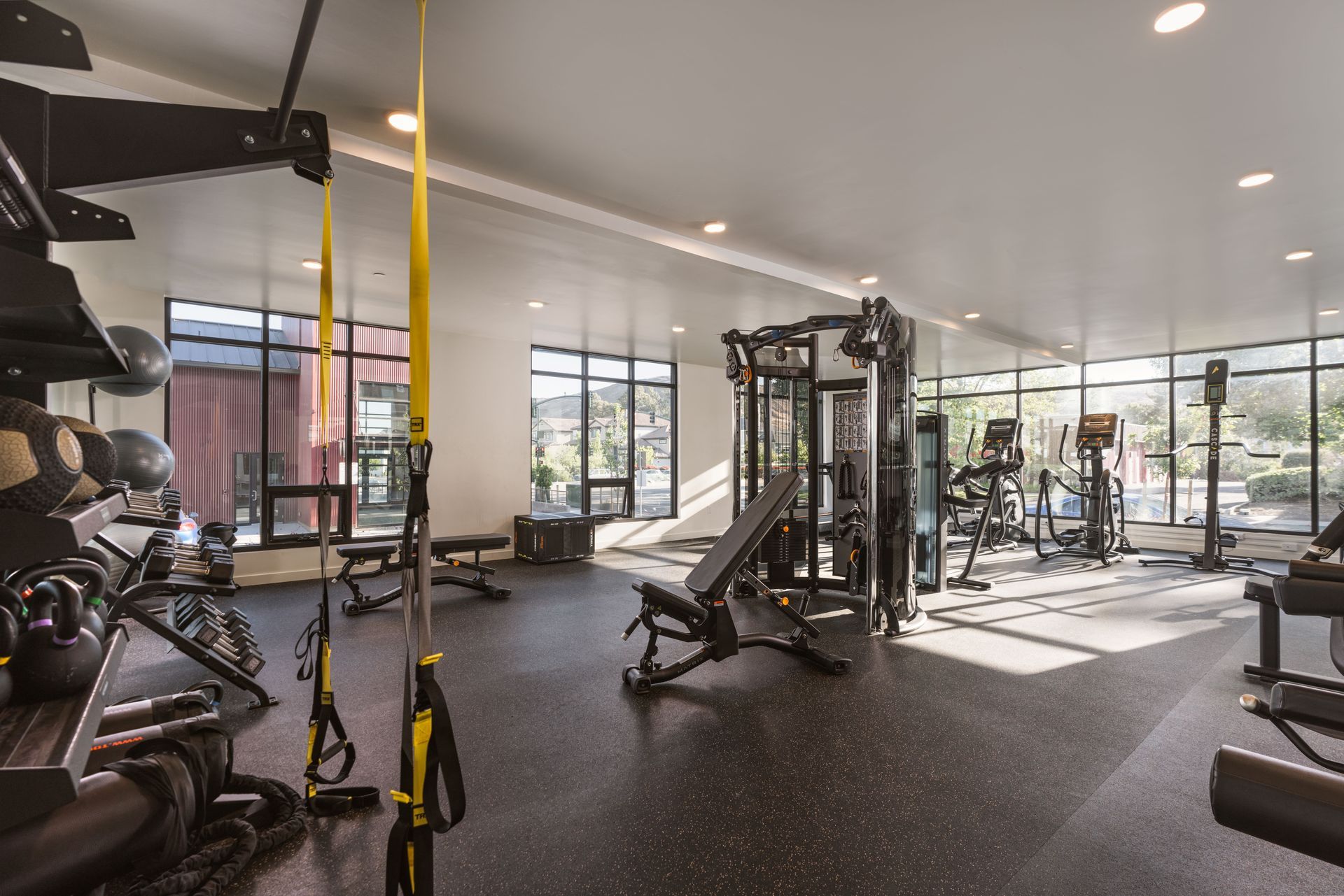 A large gym with a lot of equipment and a lot of windows.