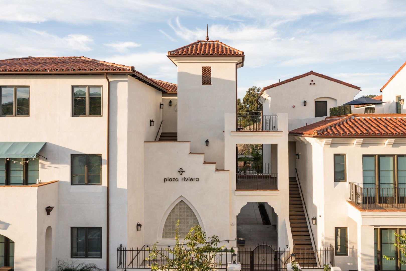 A white building with a red tile roof and stairs