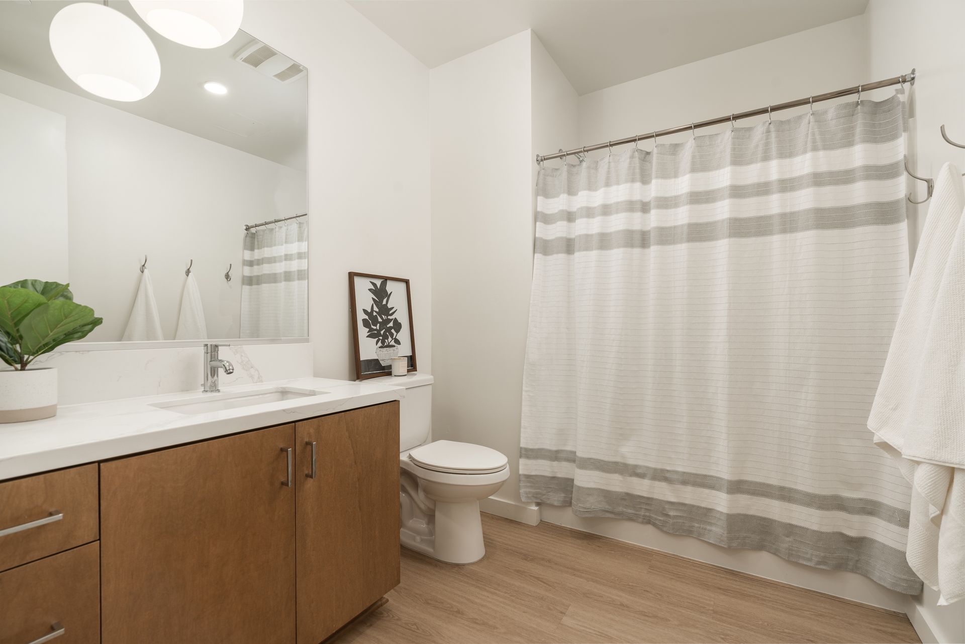 A bathroom with a toilet , sink and shower curtain.