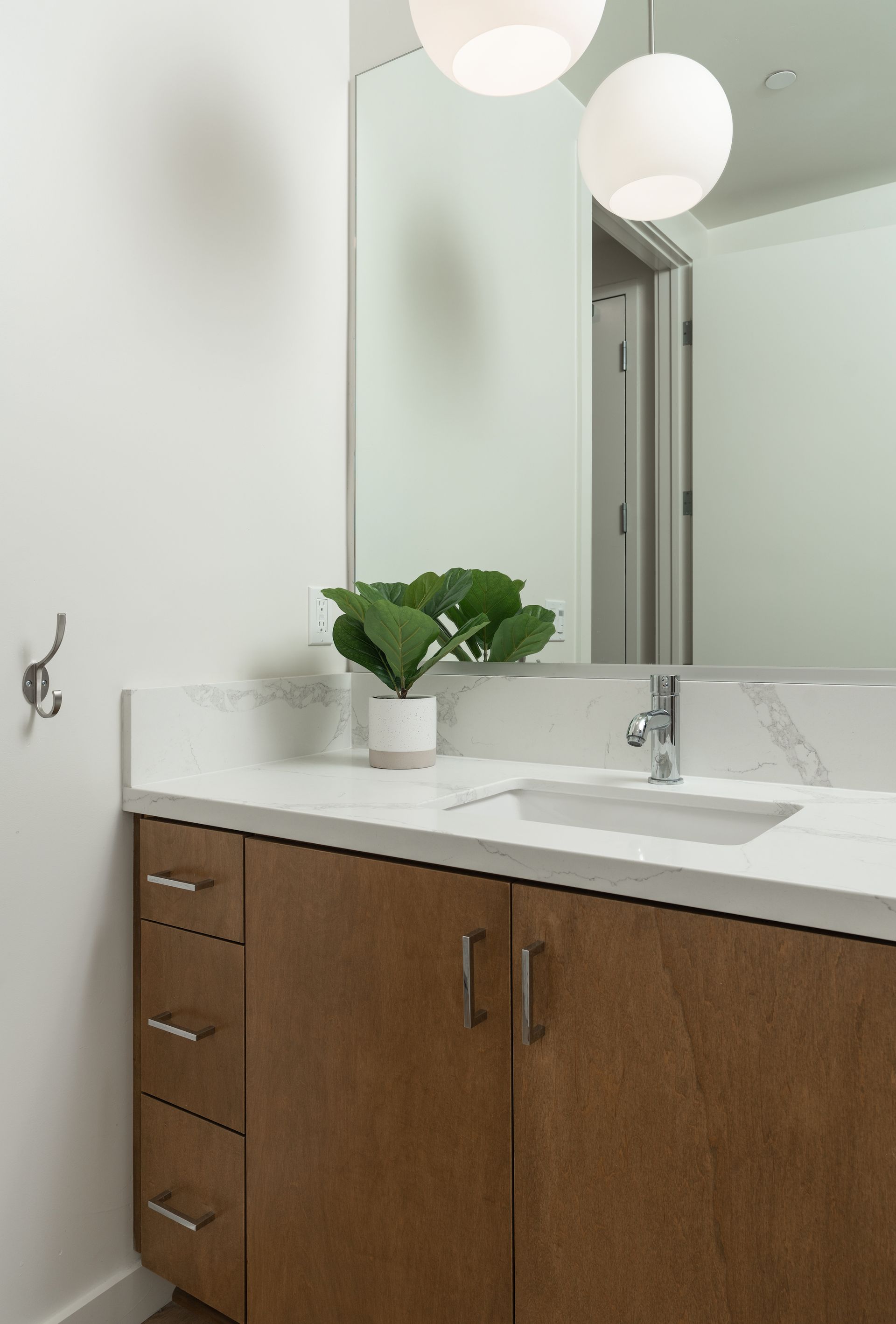 A bathroom with a sink , mirror and wooden cabinets