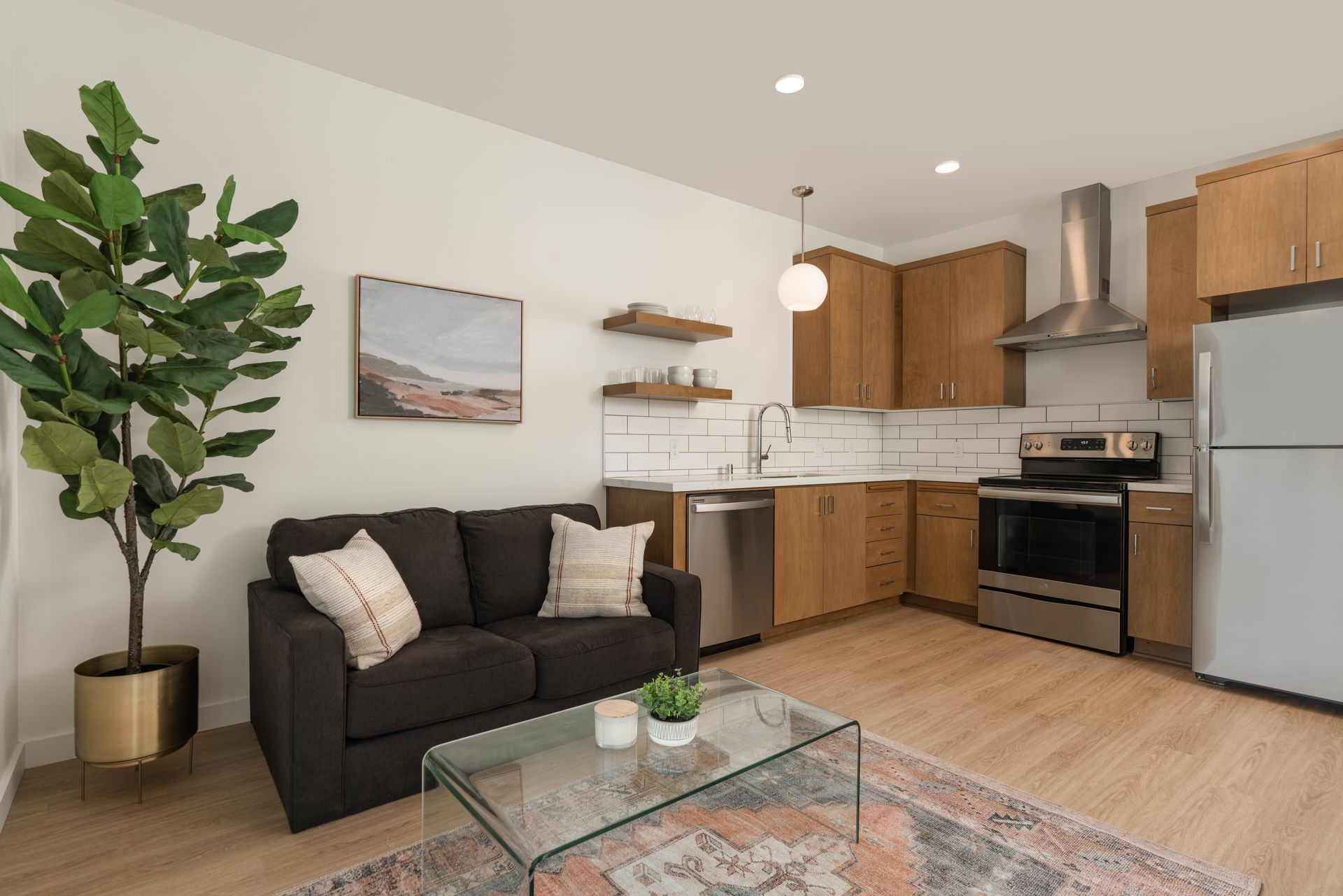 A living room with a couch , coffee table , and kitchen.