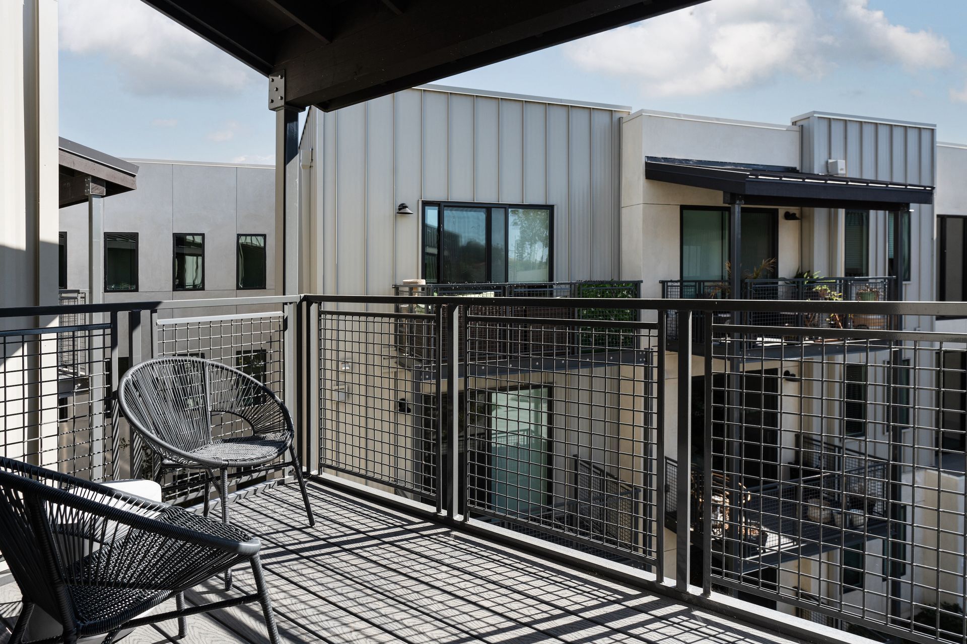 A balcony with chairs and a table in front of a building