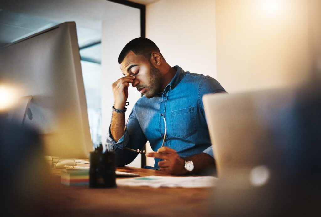 A man is sitting at a desk with a laptop and a computer.
