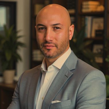 A bald man with a beard wearing a suit and tie