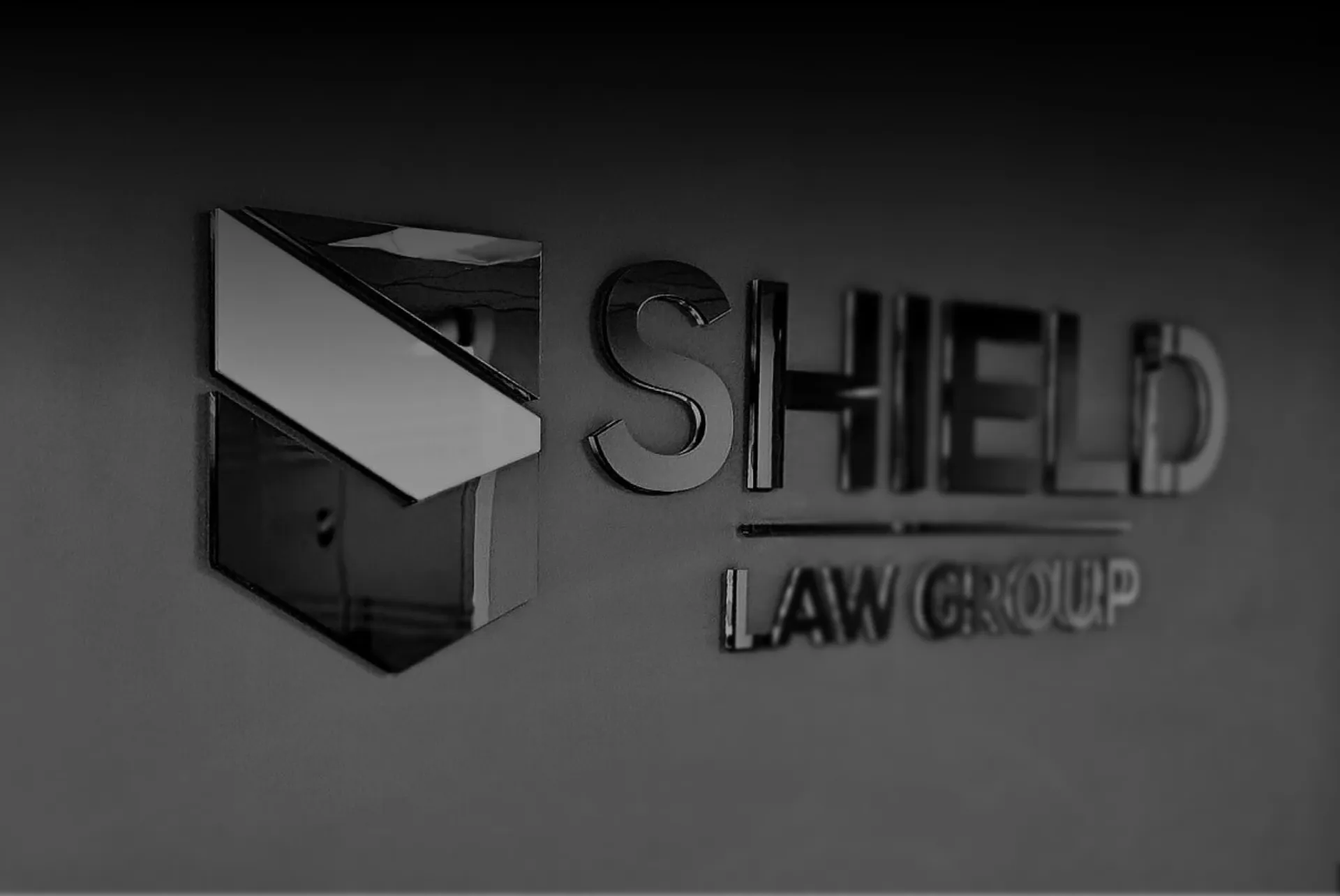 A black and white photo of the shield law group logo