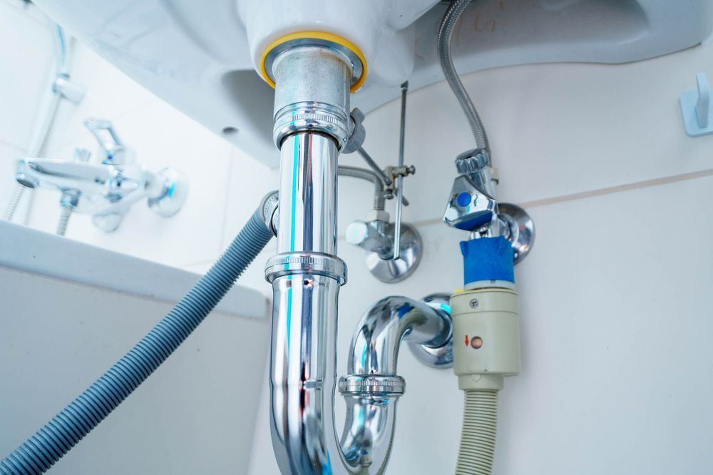A Bathroom Sink With a Hose Attached to It — Chad Warrington Plumbing In Salamander Bay, NSW