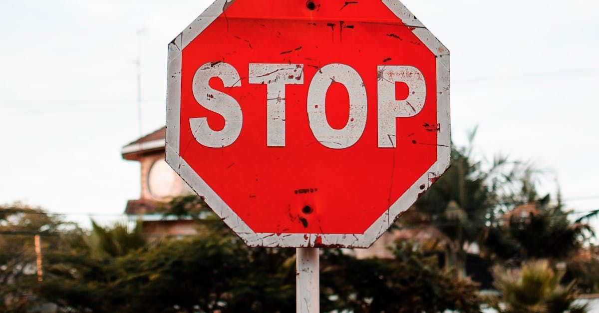 A red and white stop sign is sitting in front of a house.