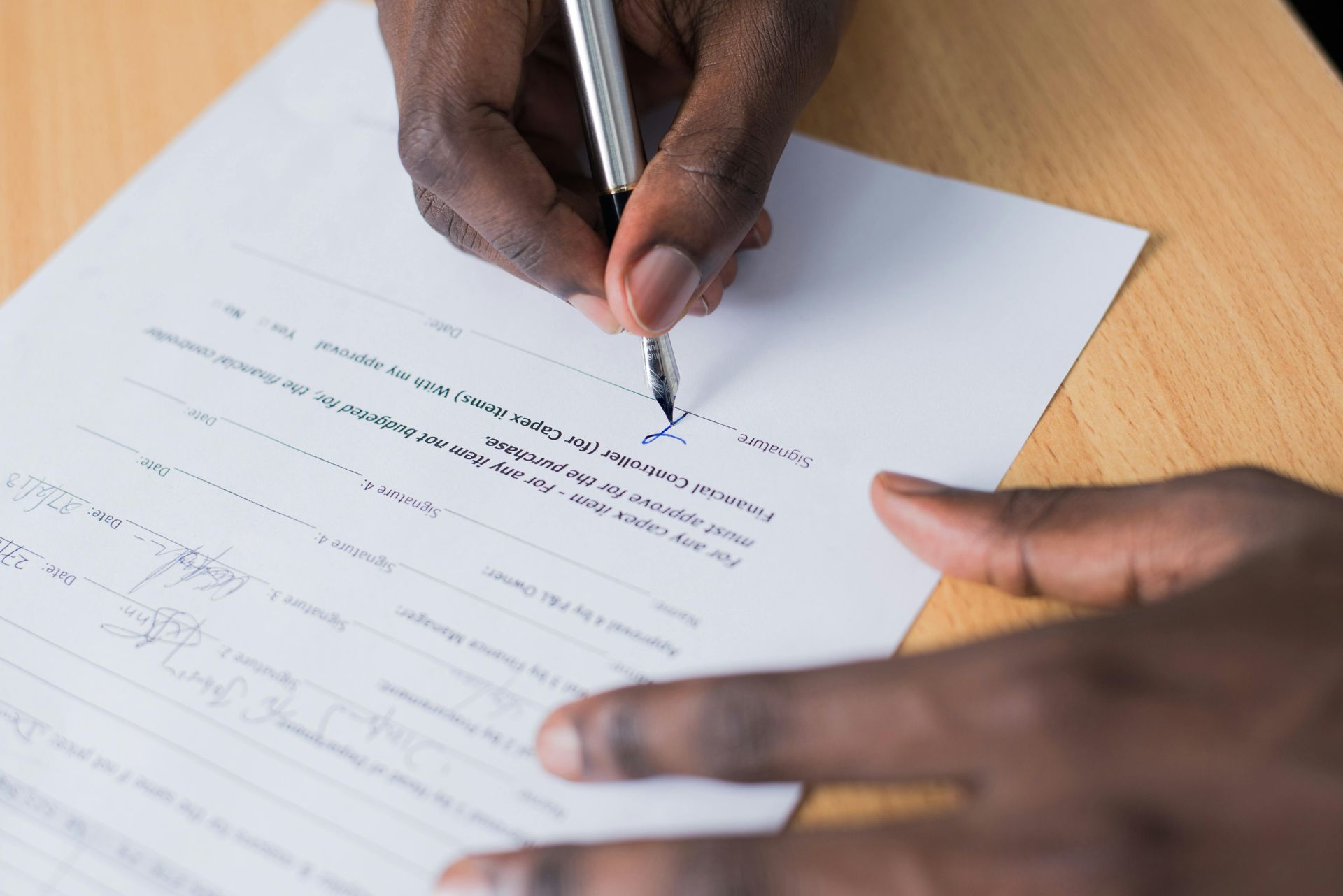 A person is writing on a piece of paper with a pen.