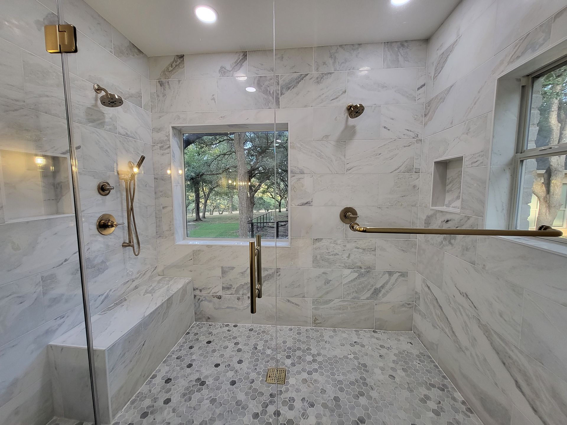 A bathroom with a walk in shower and a window.