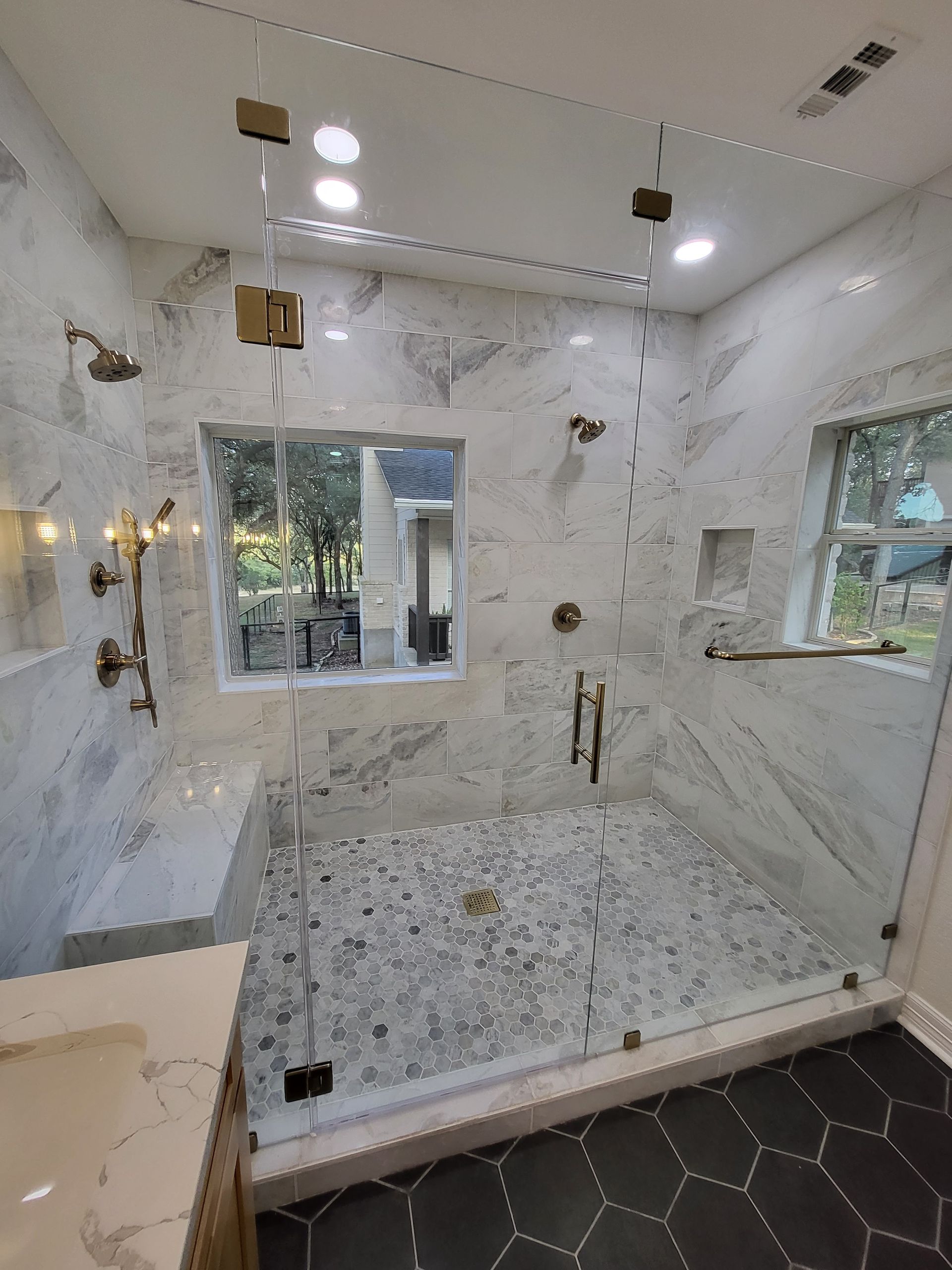 A bathroom with a walk in shower and a window.
