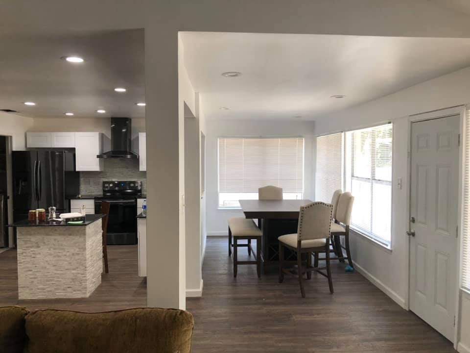 There is a table and chairs in the middle of the room.