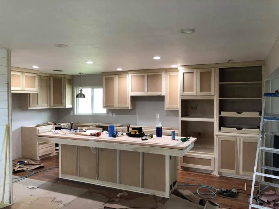 A kitchen under construction with a large island in the middle.