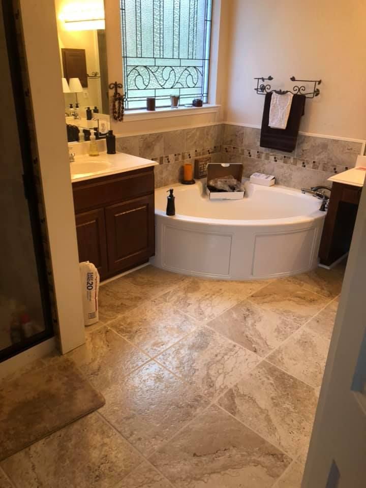 A bathroom with a tub , sink , and mirror.