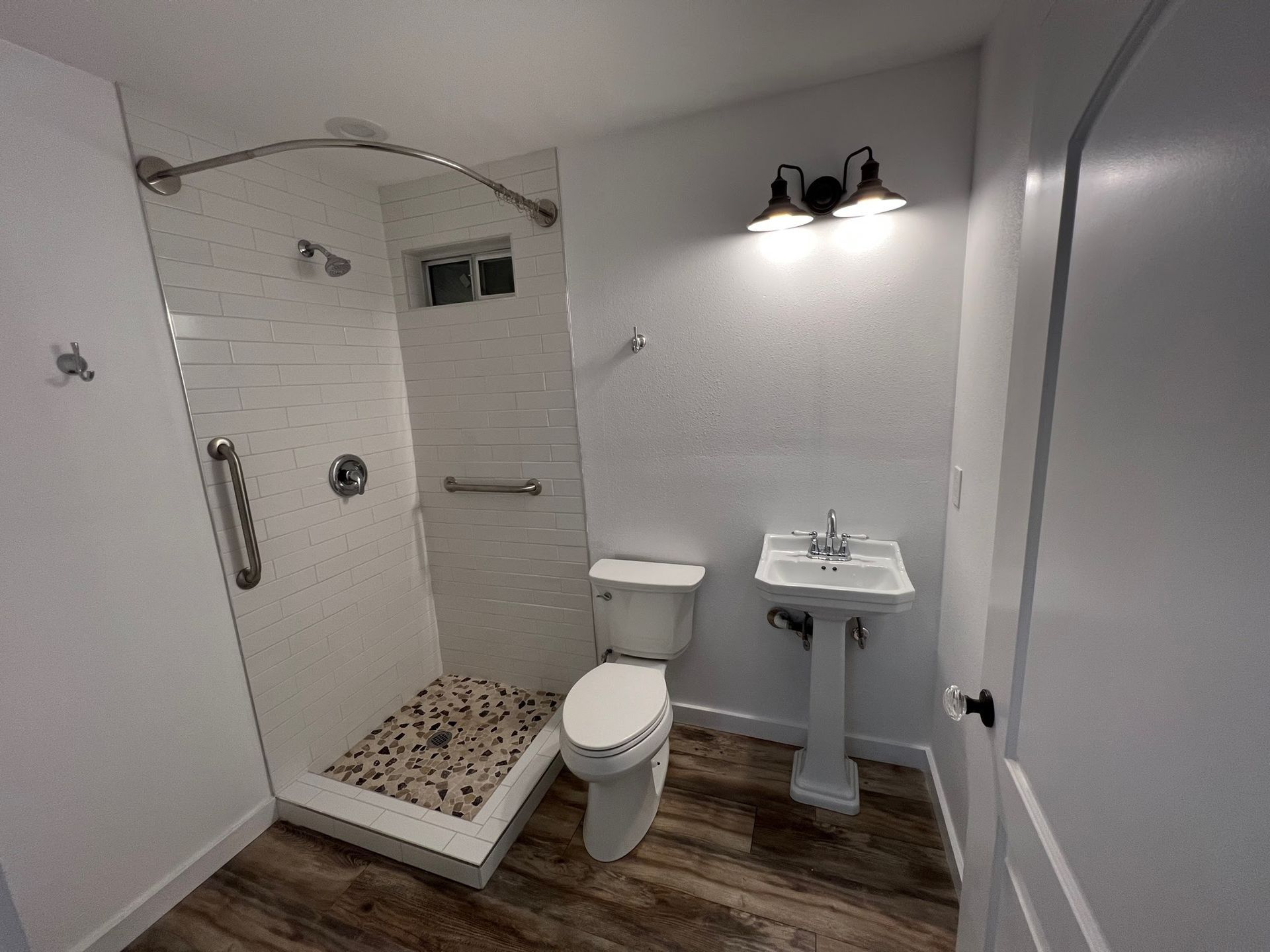 A bathroom with a toilet , sink and shower.