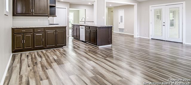 A dog standing in a living room next to a table and chairs
