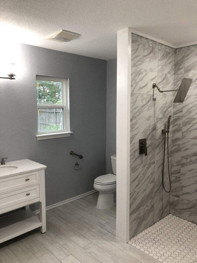 A bathroom with a toilet , sink , and walk in shower.