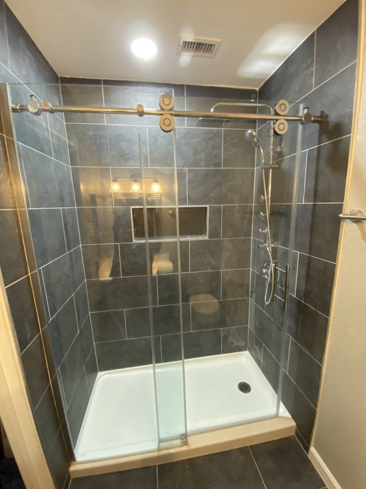 A bathroom with a sliding glass shower door and a shower head.