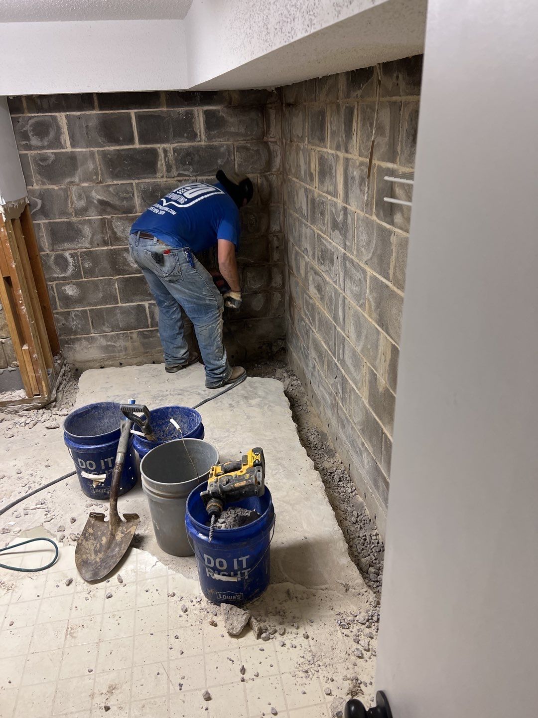 a man is working on a brick wall in a basement .