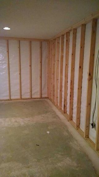 a basement with wooden walls and a concrete floor .