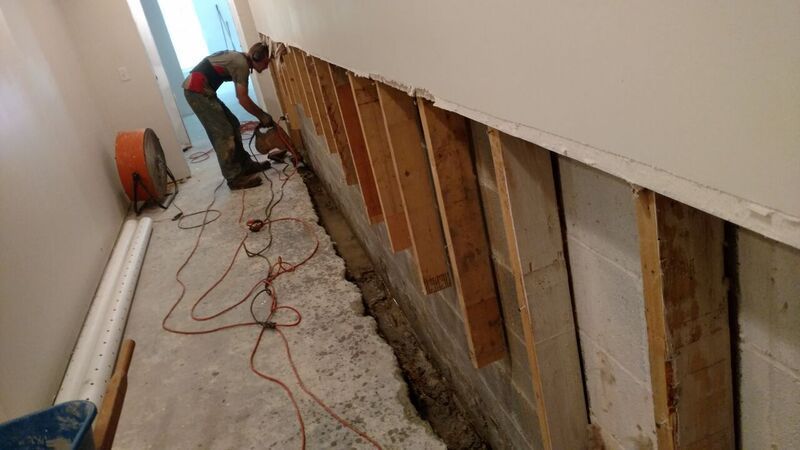 a man is working on a wall in a basement .