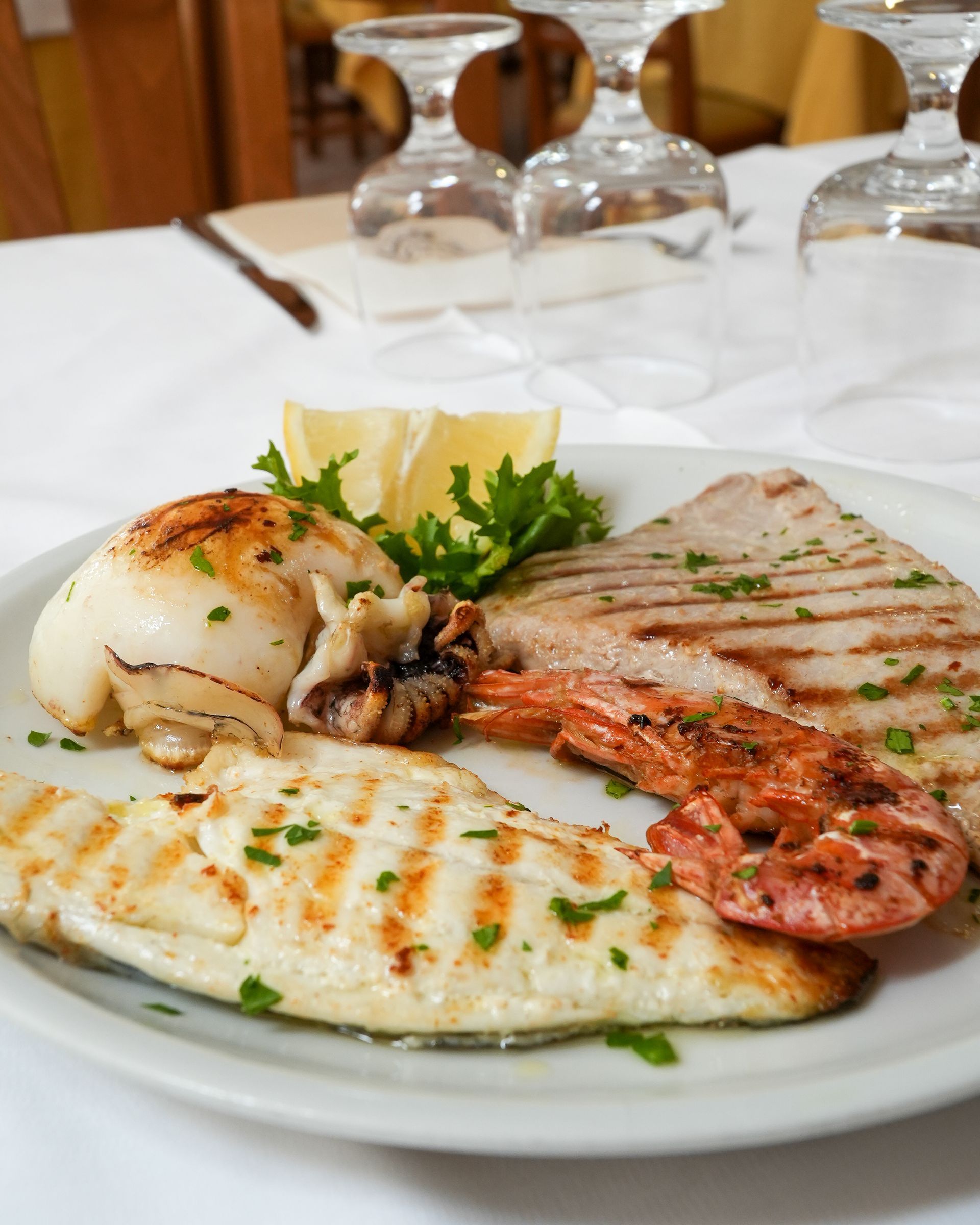 Grilled steak with mashed potatoes and vegetables on a white plate in a restaurant setting