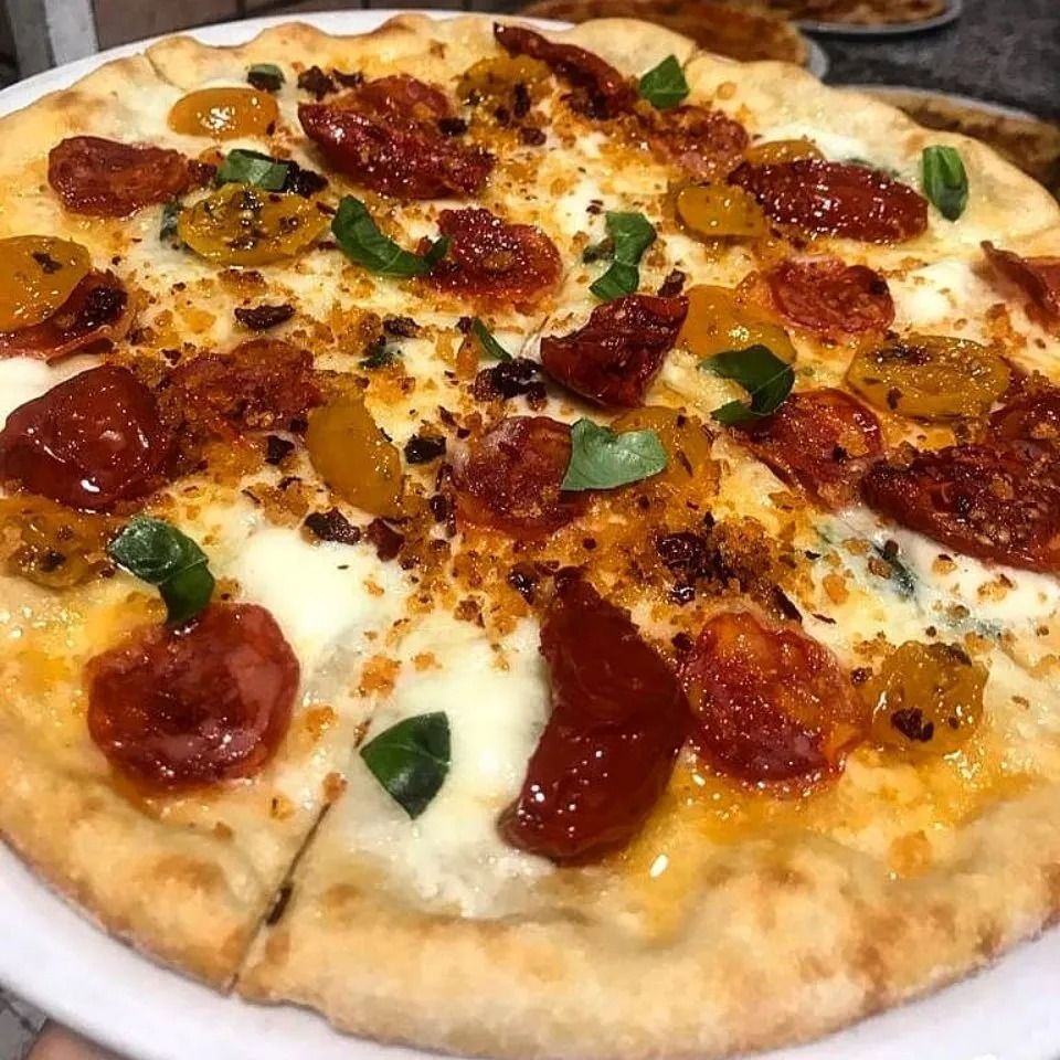 Pepperoni and cheese pizza with basil leaves and a golden crust
