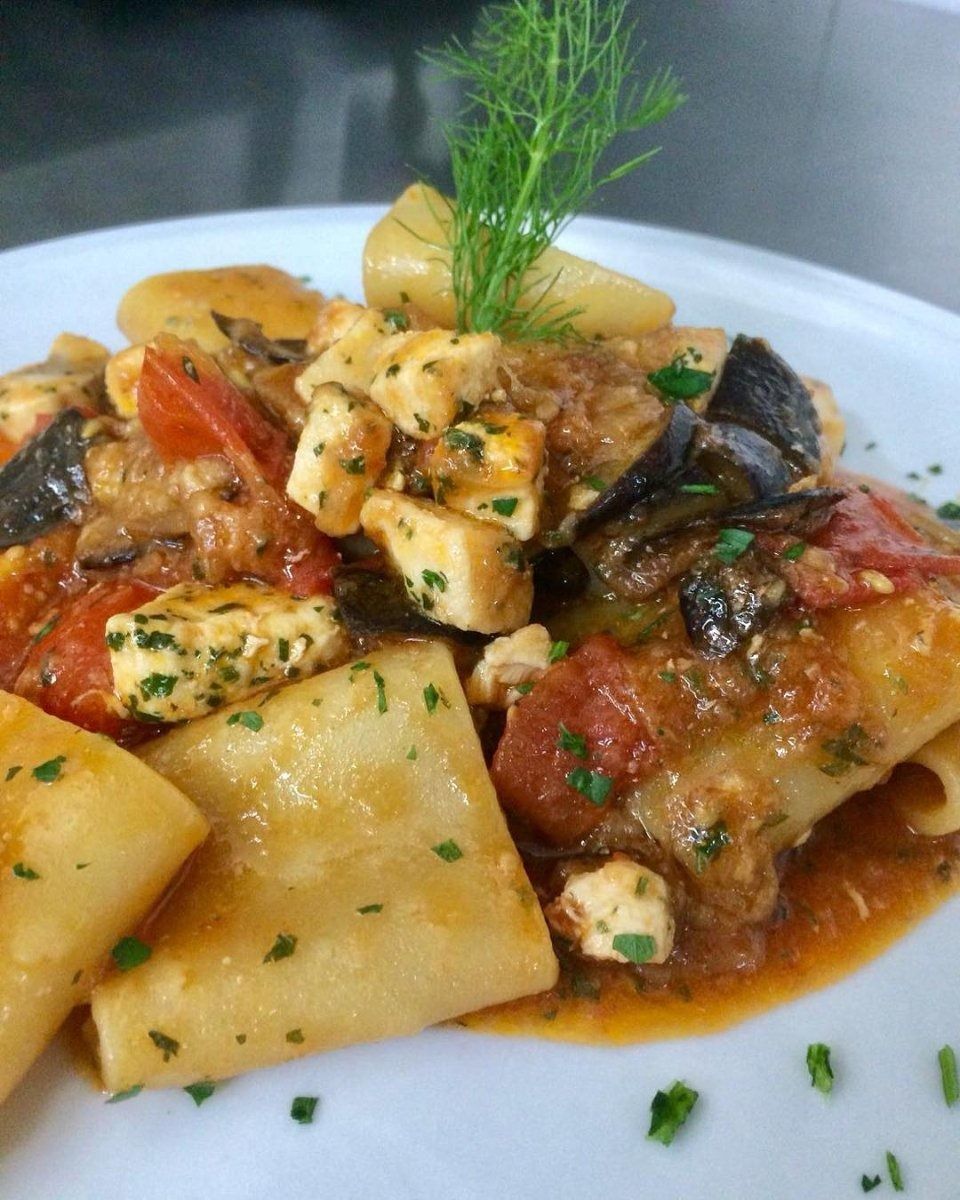 Pasta ai frutti di mare con salsa di pomodoro, erbe aromatiche e un rametto di aneto.