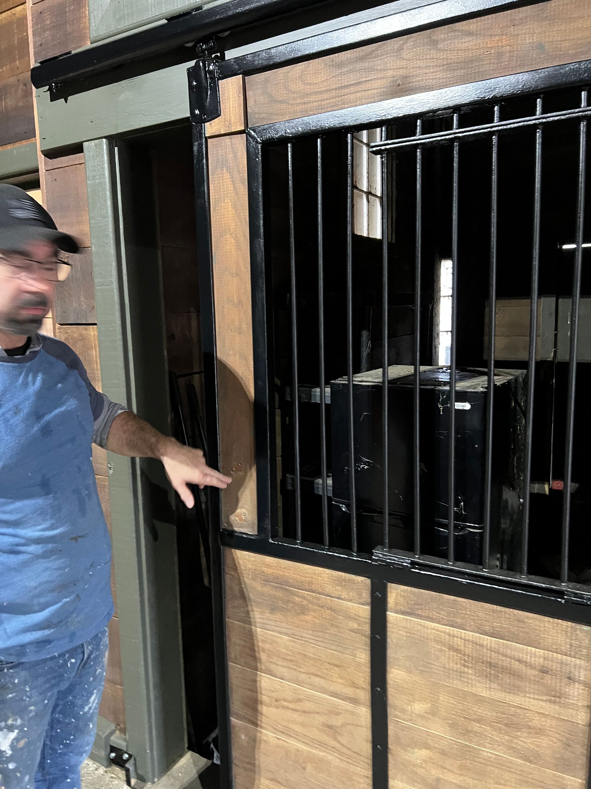 A man is standing in front of a sliding barn door.