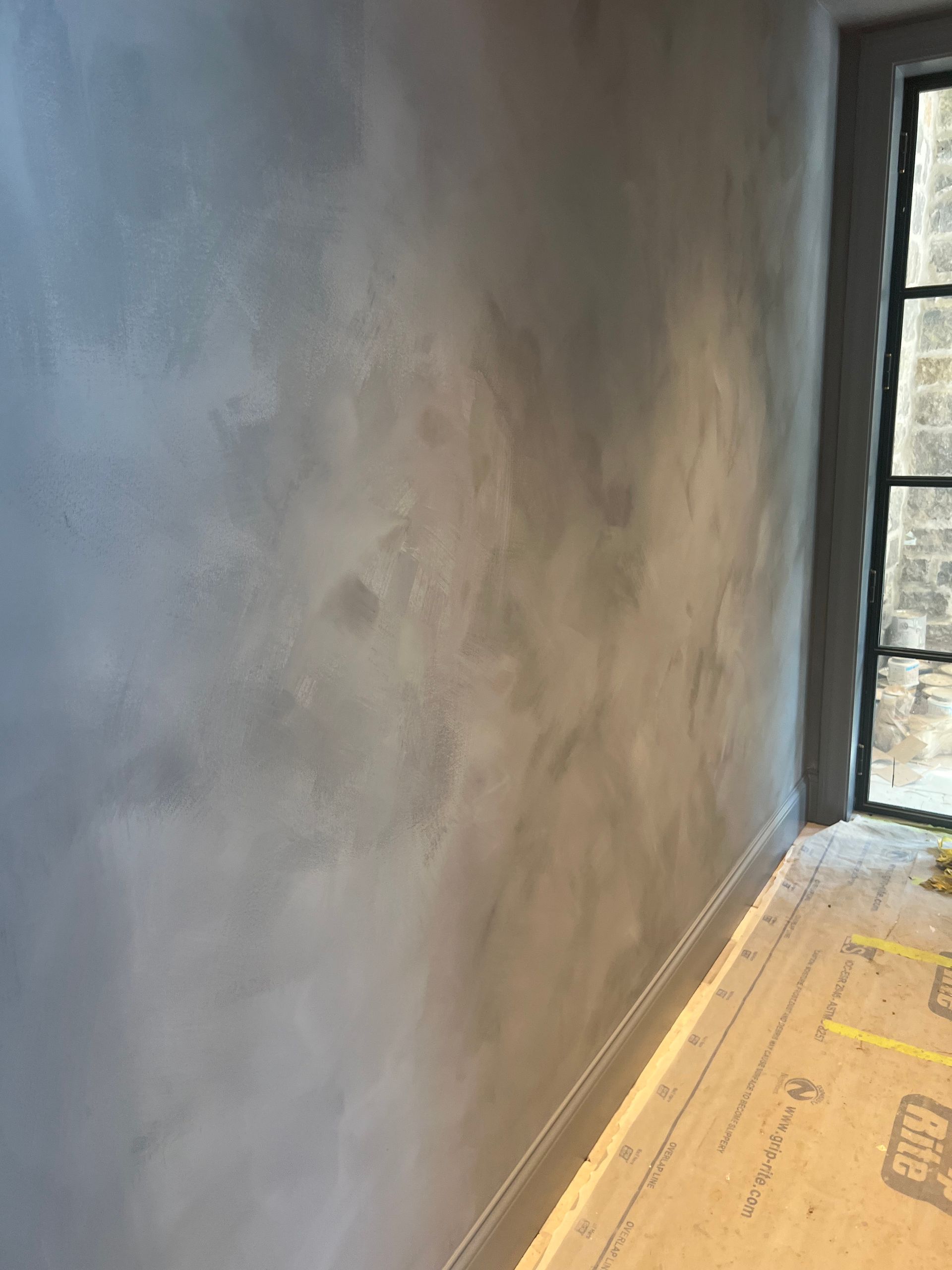 A room with a gray wall and a window.