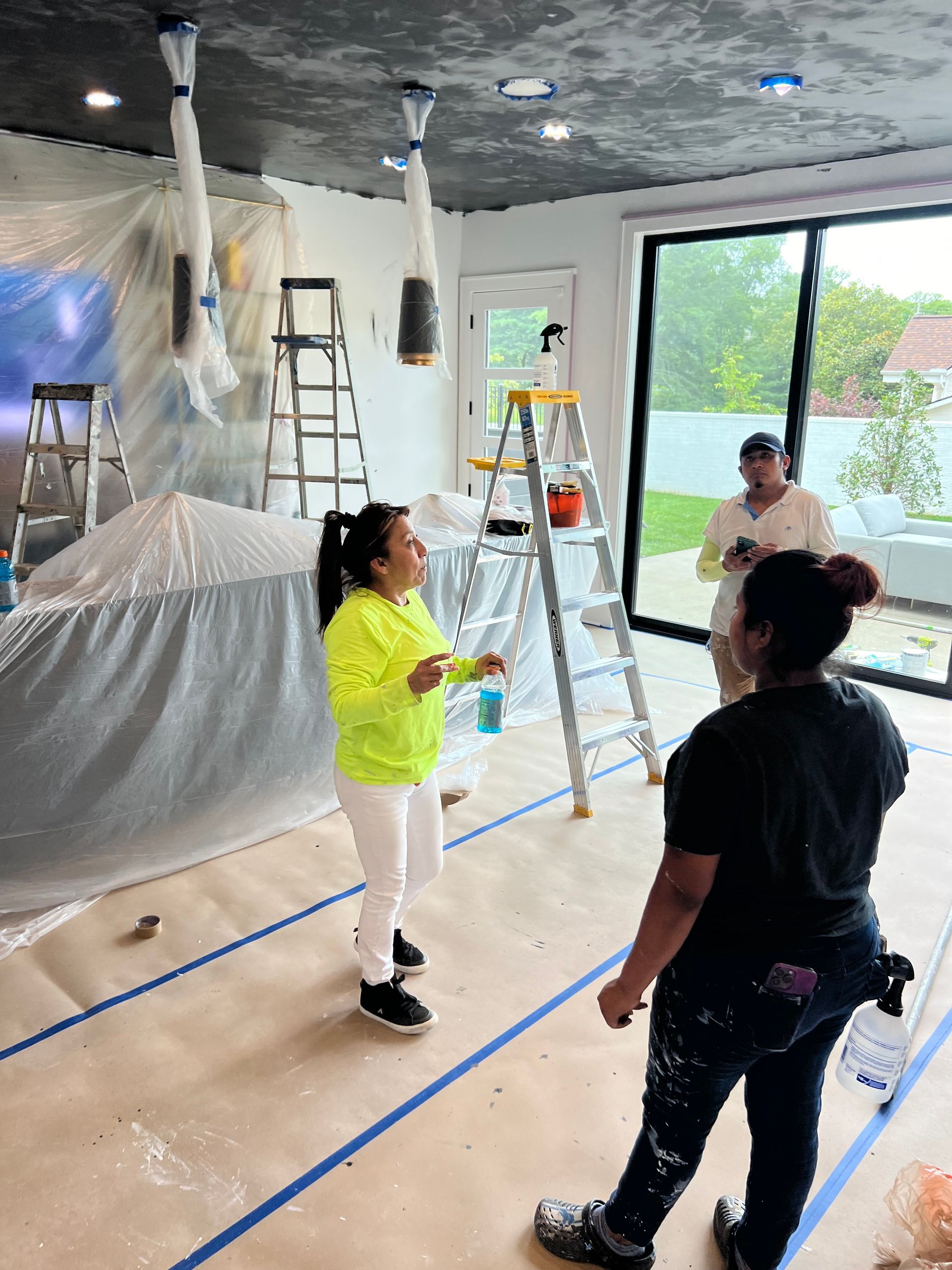 A group of people are standing in a room covered in plastic.
