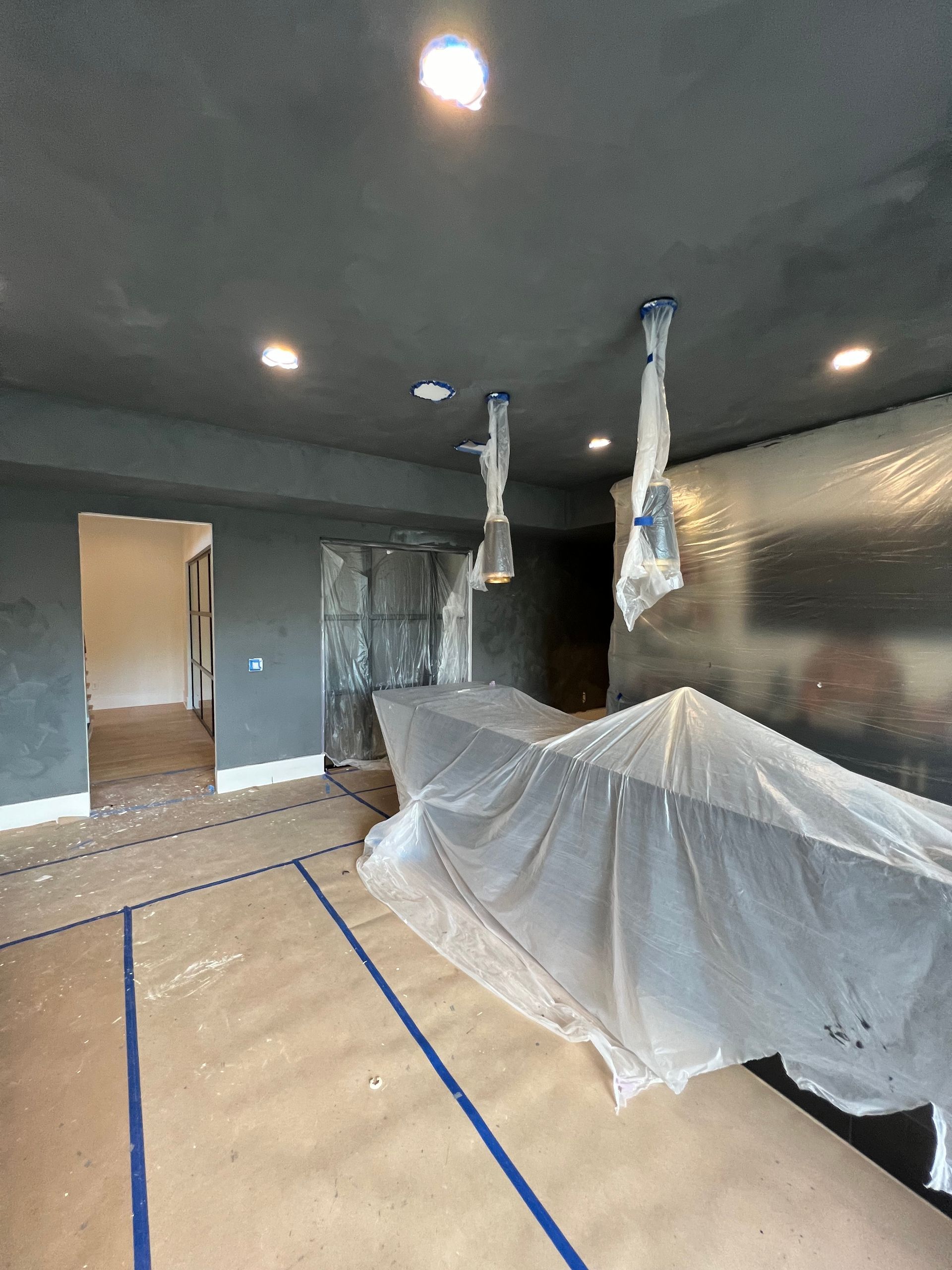 A room with a piano covered in plastic.