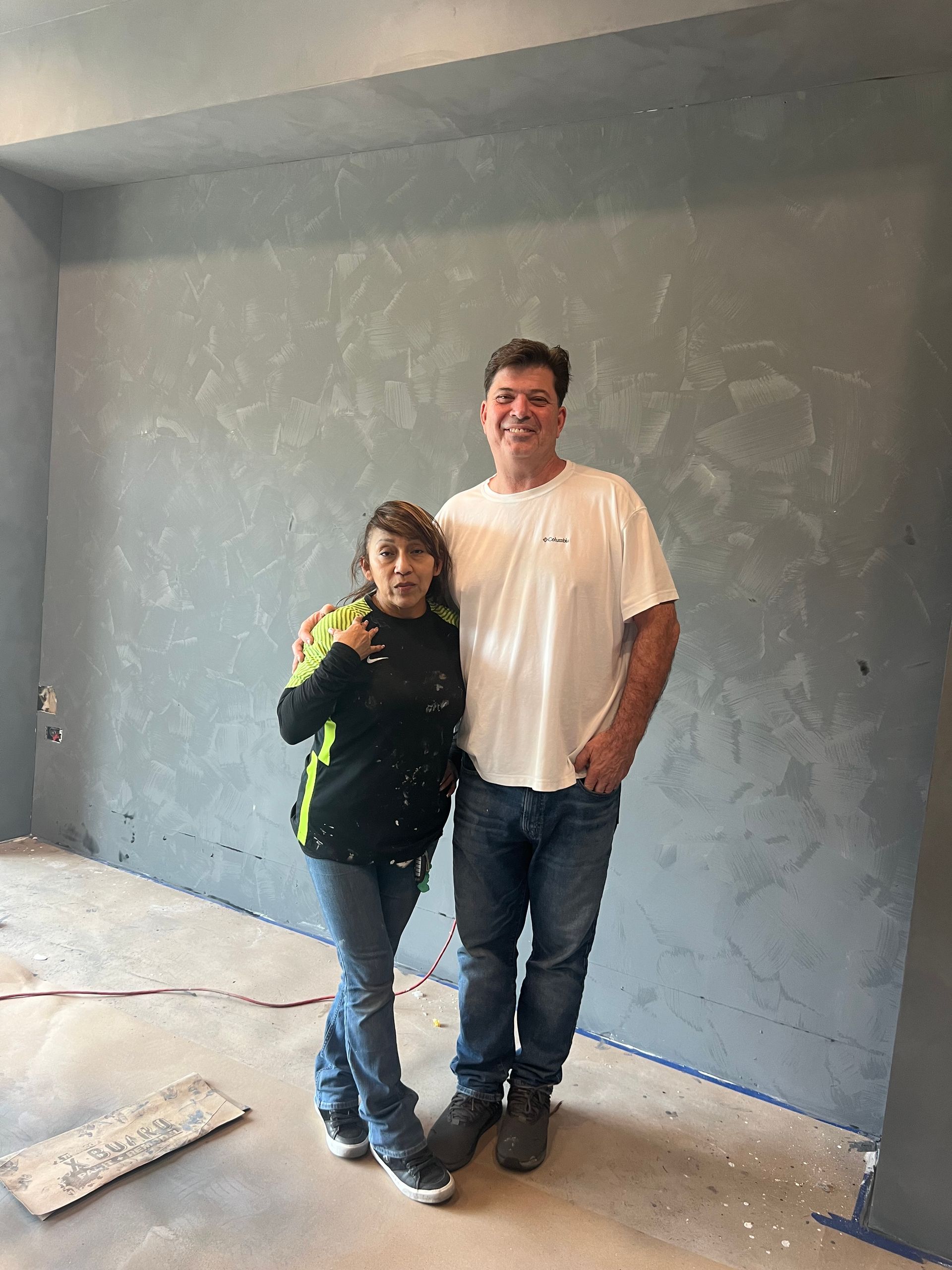 A man and a woman are standing next to each other in a room.