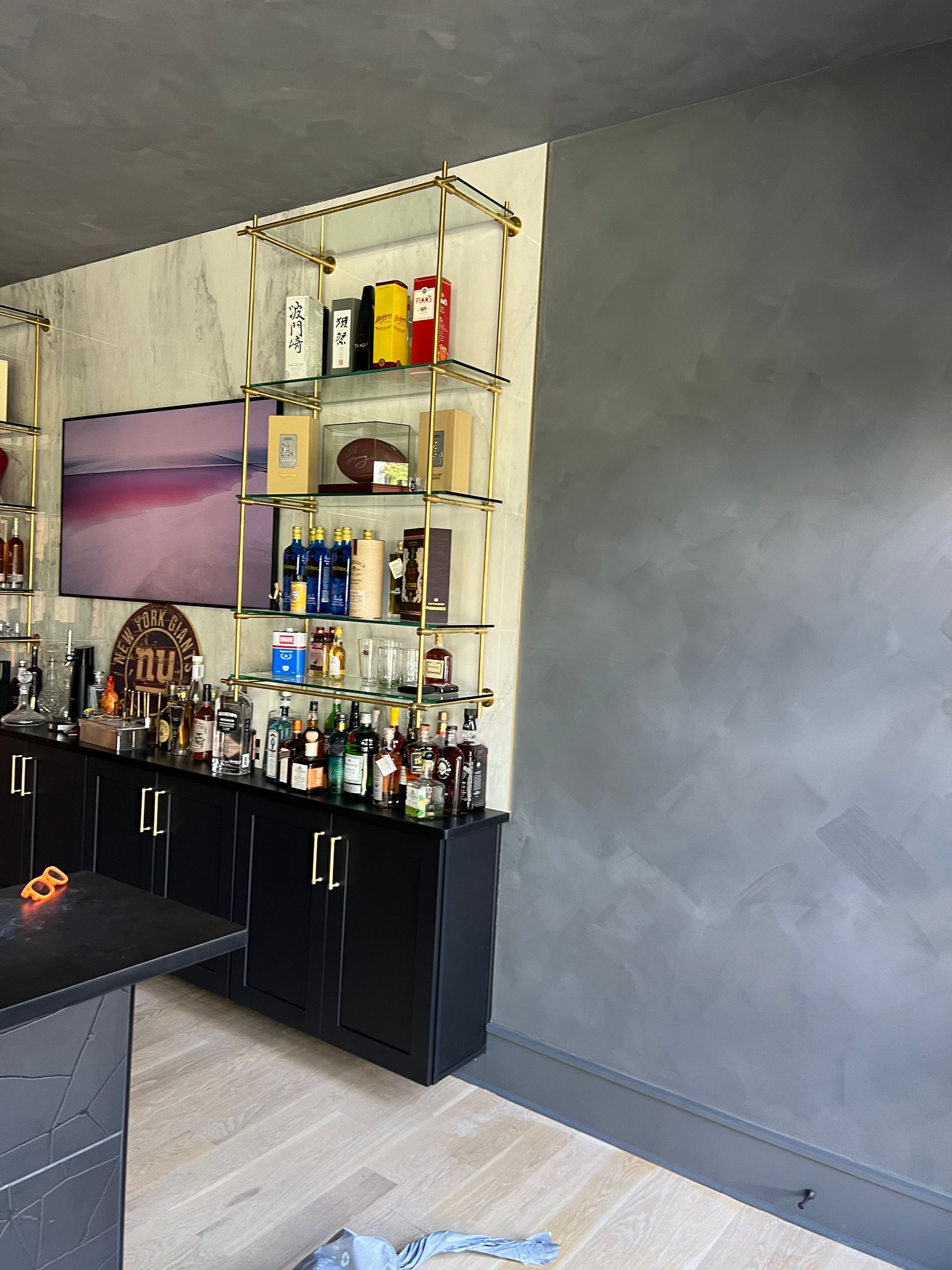 A kitchen with a lot of bottles on shelves