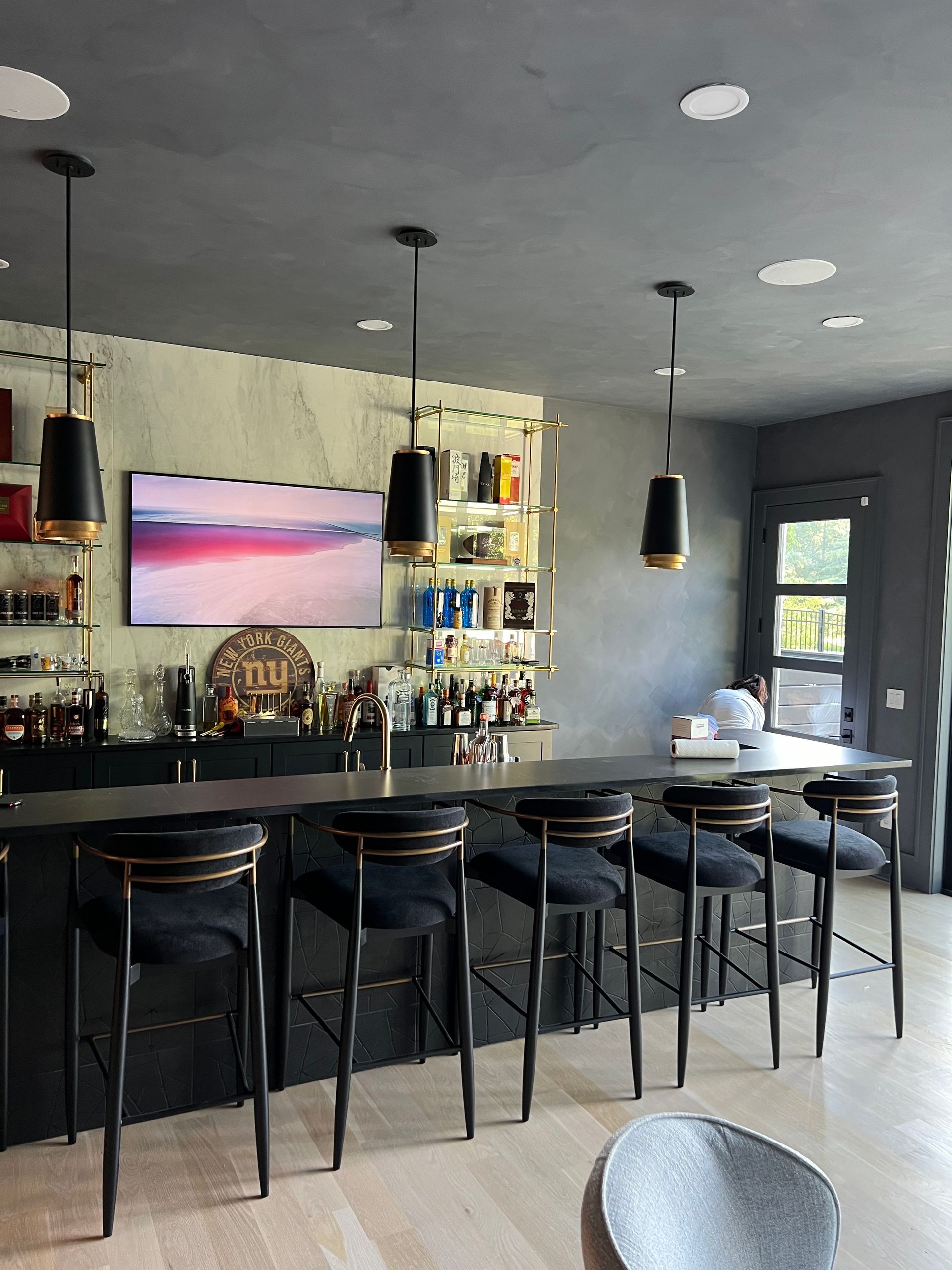 A bar with a long table and stools in a living room
