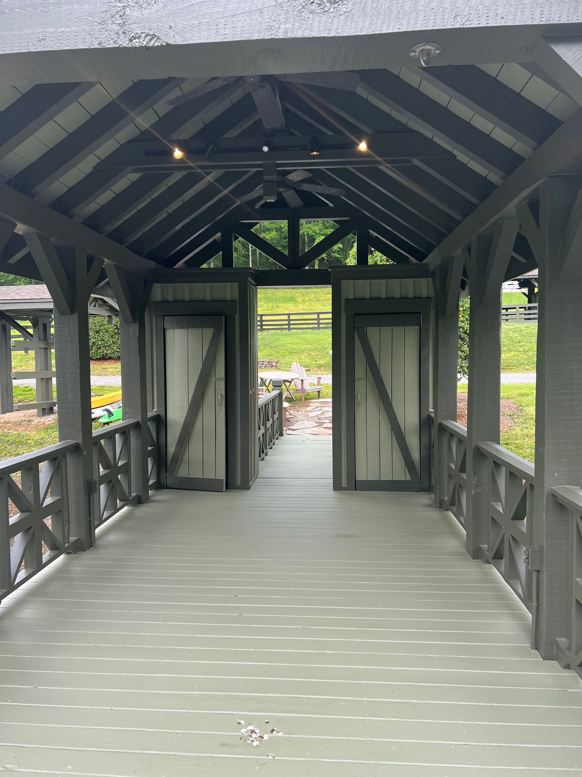 A covered walkway leading to a barn with the doors open