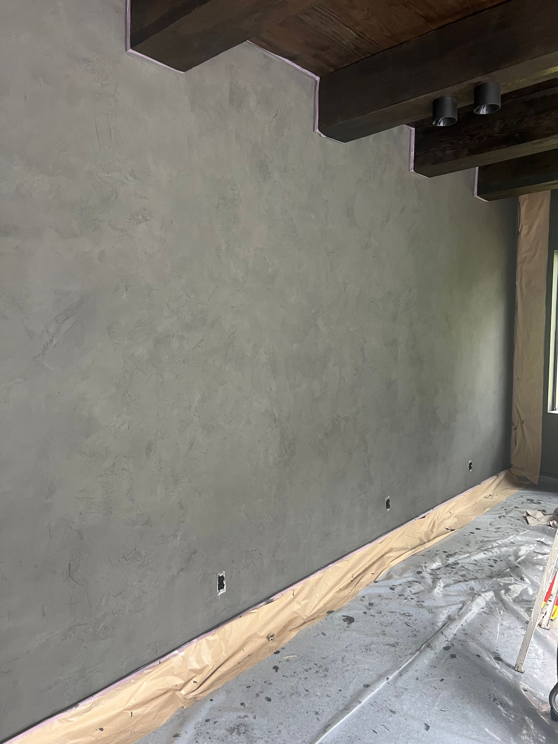 A room with a gray wall and a wooden floor.