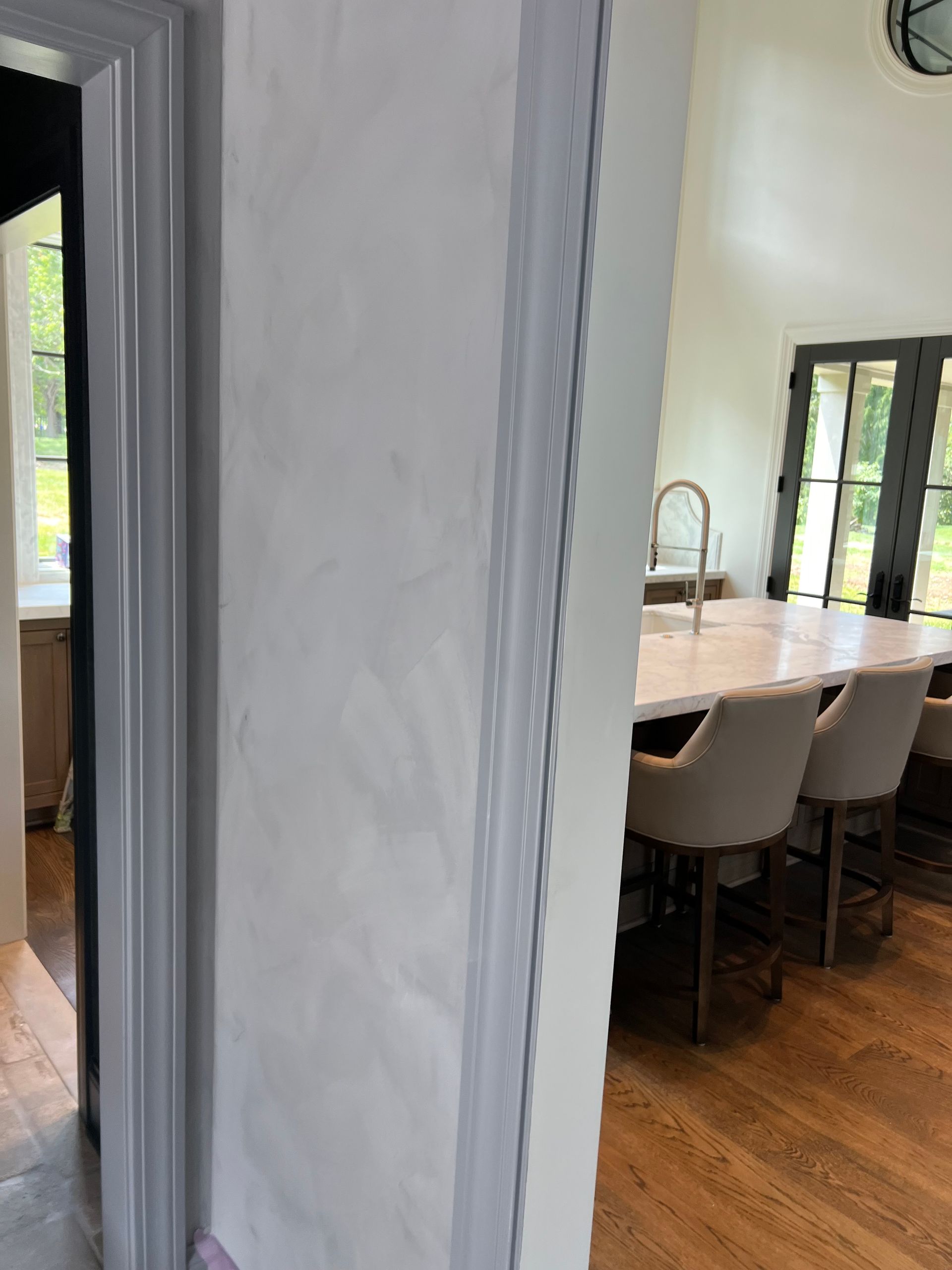 A kitchen with a table and chairs and a doorway leading to a dining room.