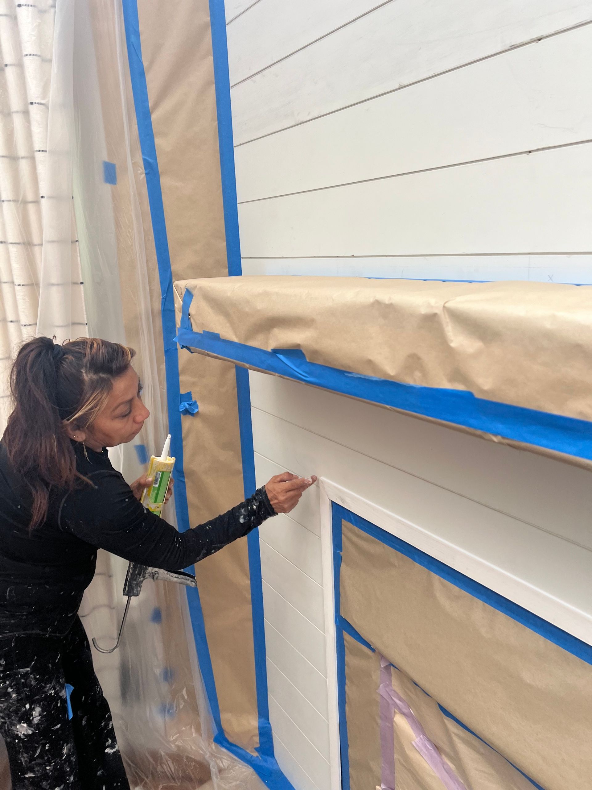 A woman is painting a wall with a brush