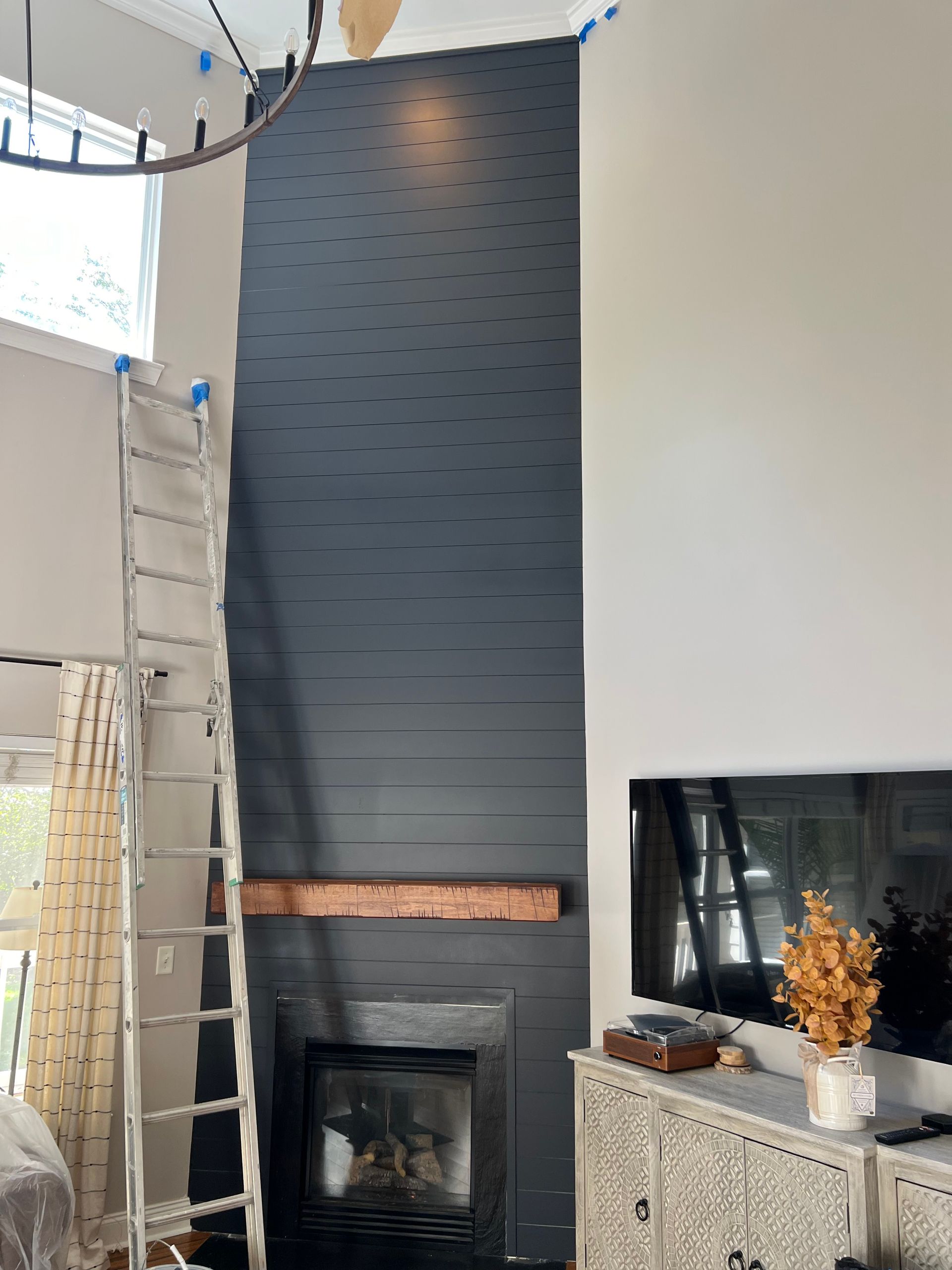 A living room with a fireplace and a ladder.